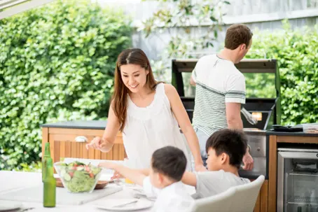 family preparing lunch at their outdoor kitchen